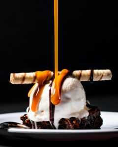 a chocolate cookie with white ice cream and caramel drizzle