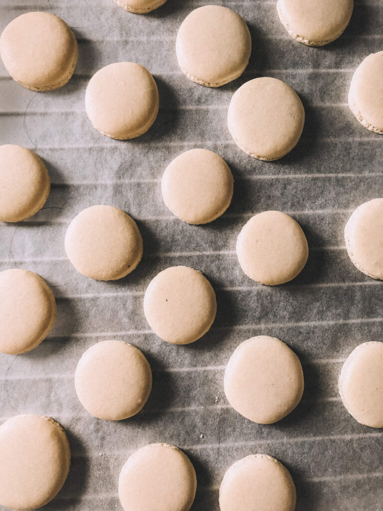 vanilla macarons laid out on a towel