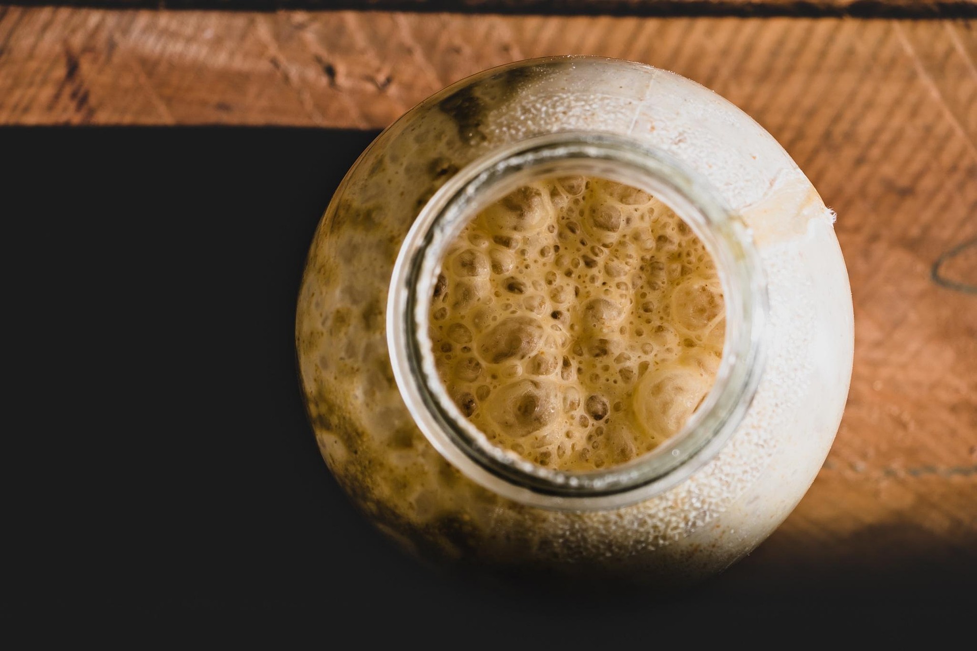 A jar containing active bread yeast and proofing ahead of use