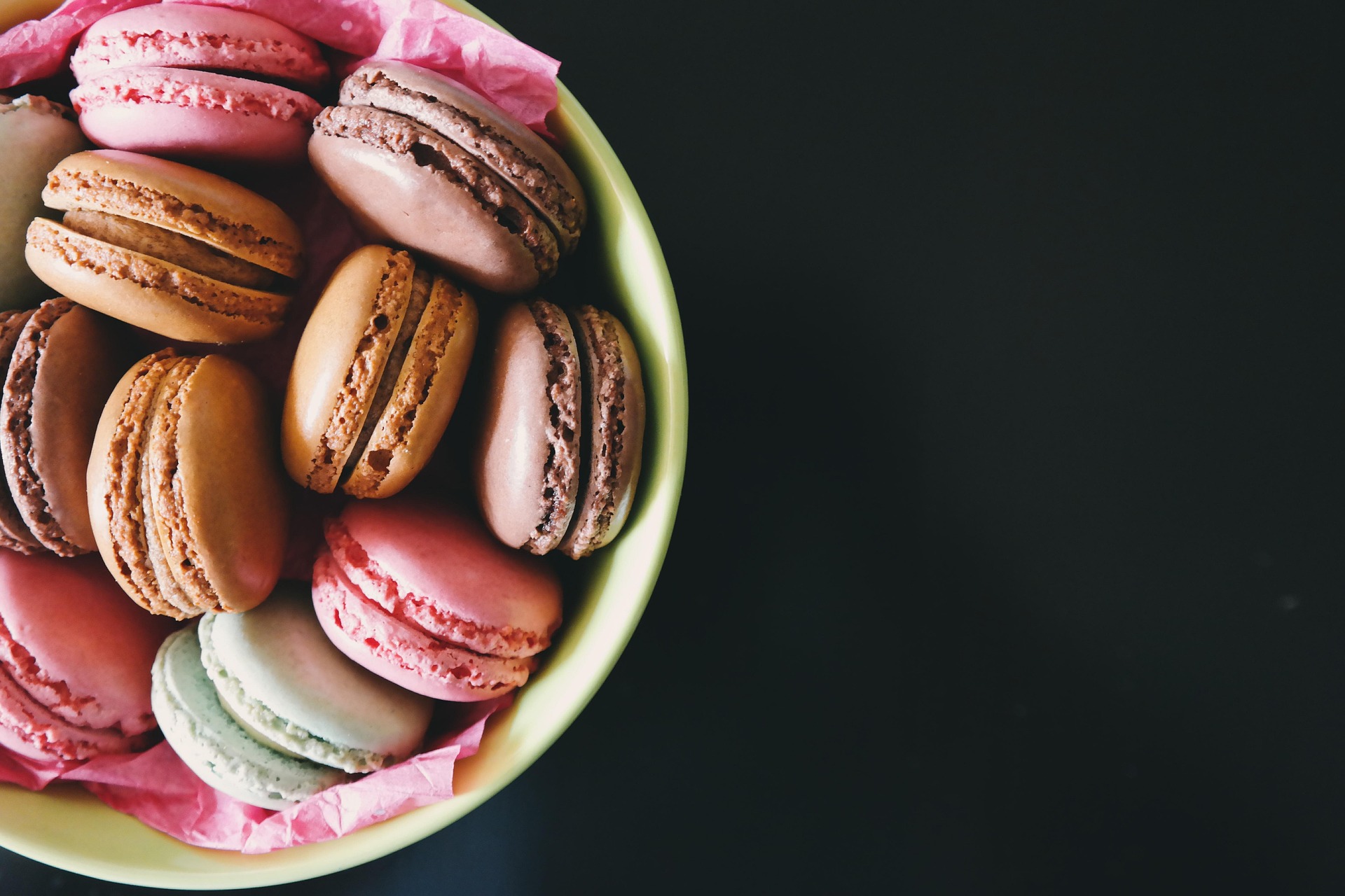 A bowl full of macarons in colorful flavors