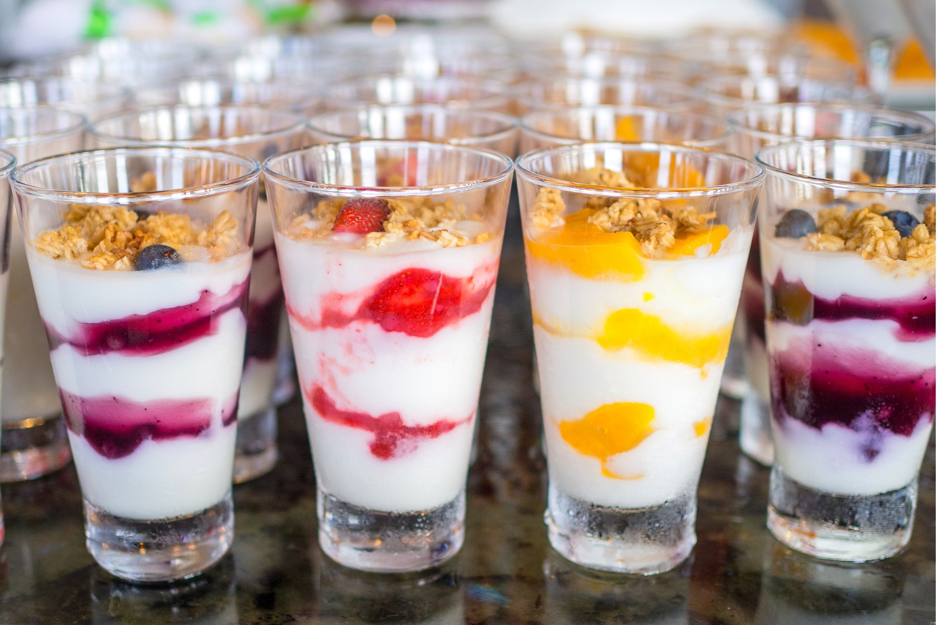 A selection of yogurt parfait cups for breakfast lined up on the counter