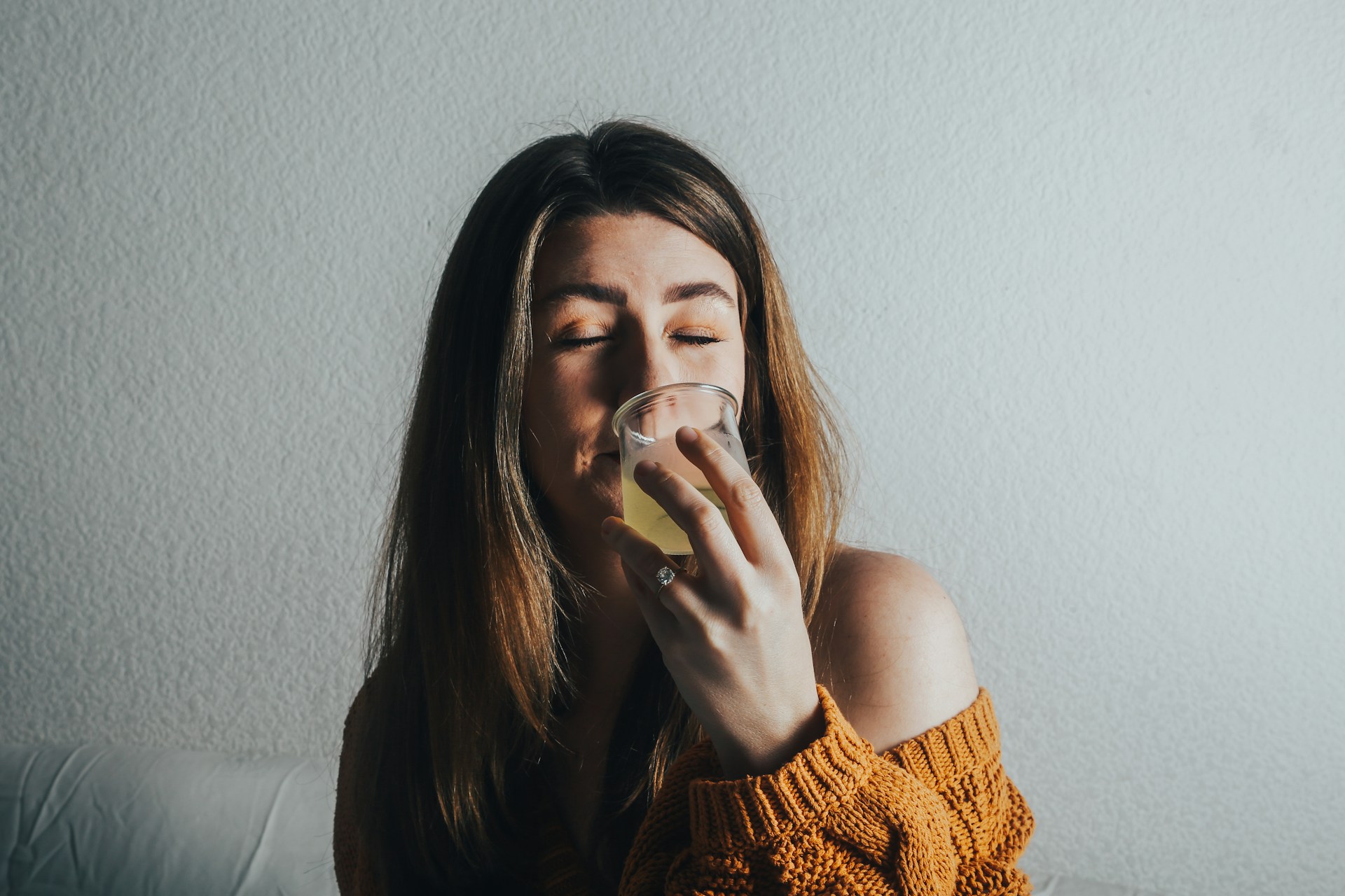 A lady reluctantly trying a botanical drink without taste masking in it