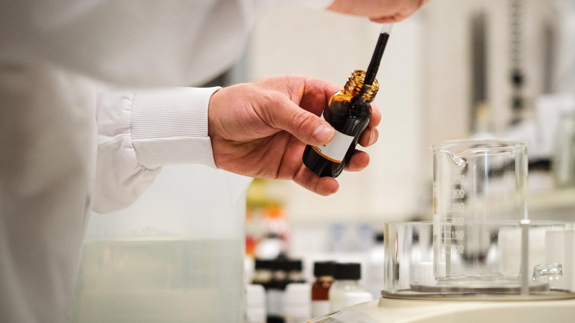 Flavorist in a laboratory, dropping some flavor drops from a sample